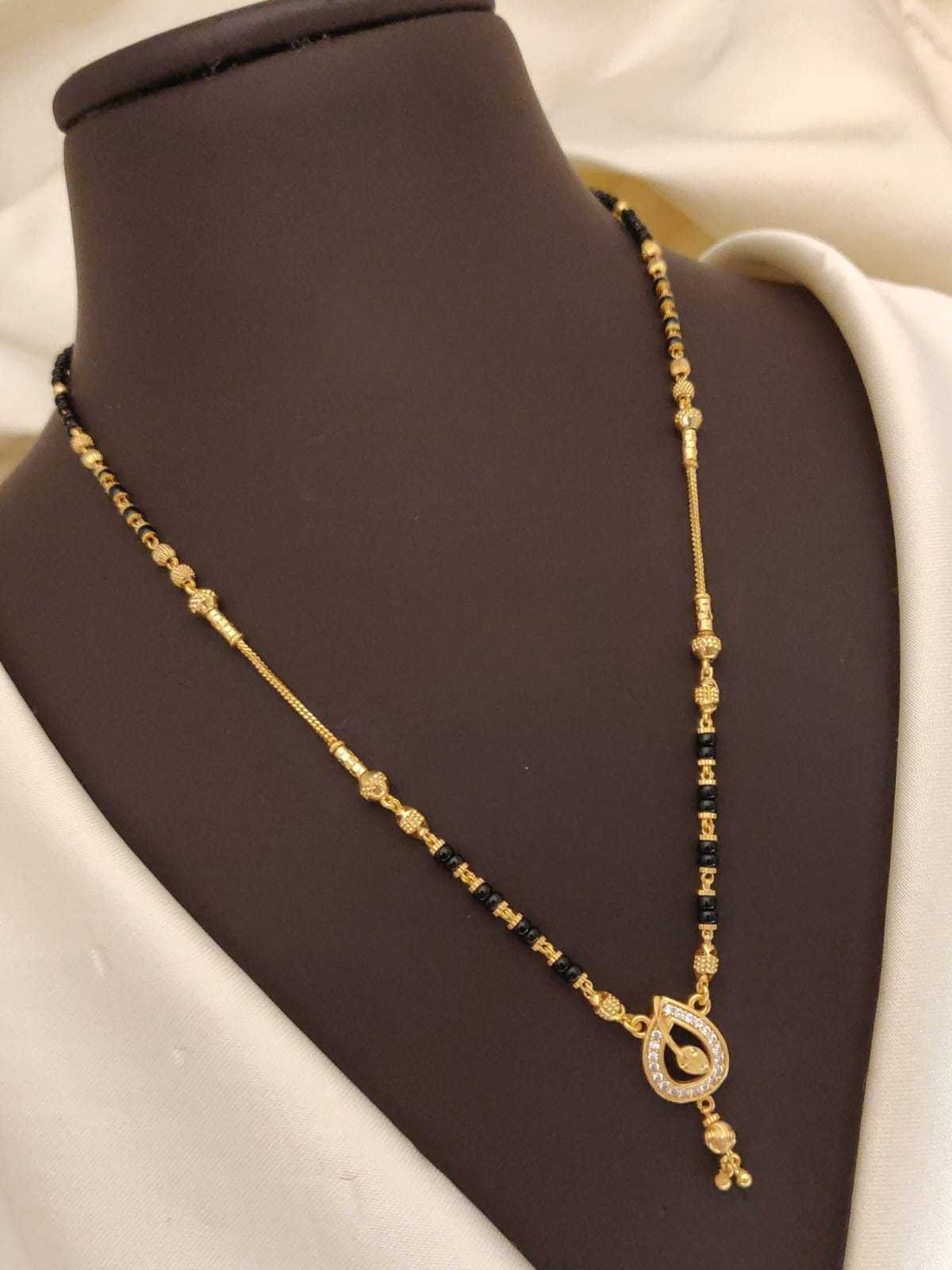 Gold and black beaded necklace on a mannequin