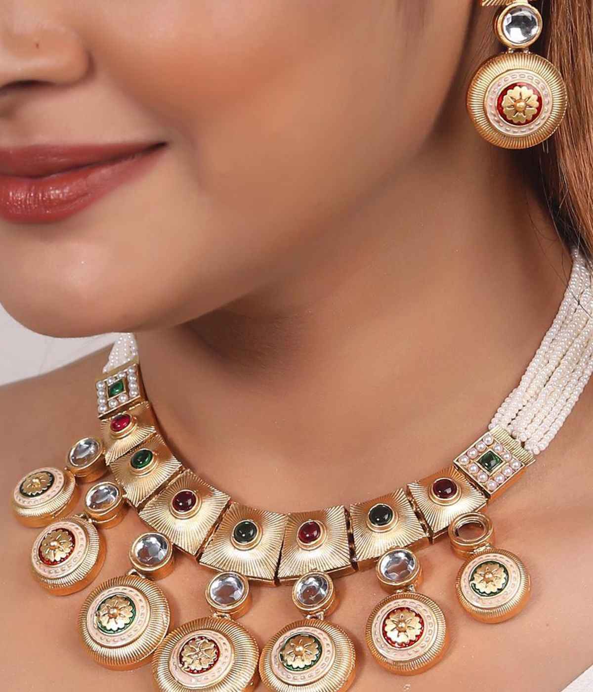 Gold necklace and earrings on a model with a neutral background