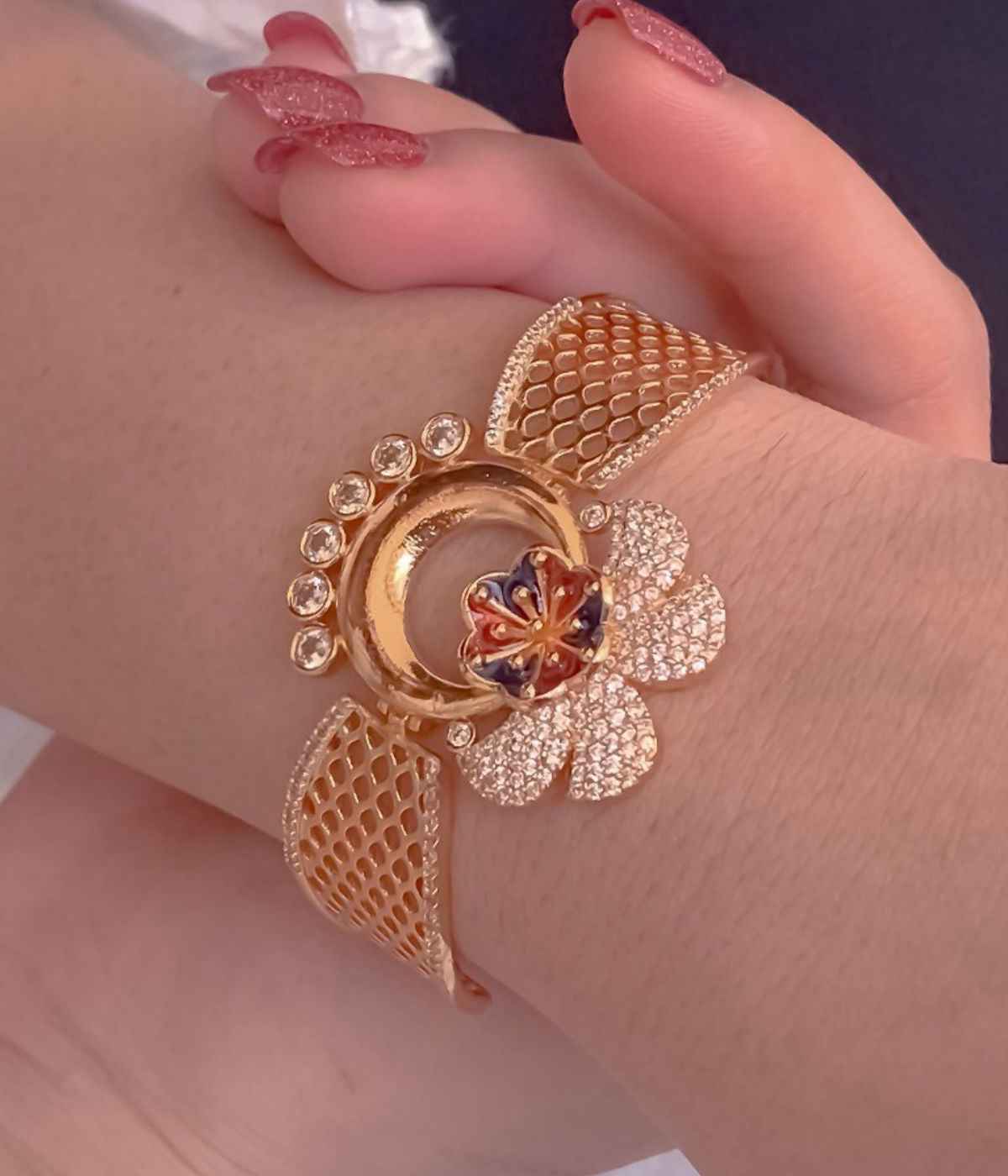Rose gold bracelet with floral design on a wrist