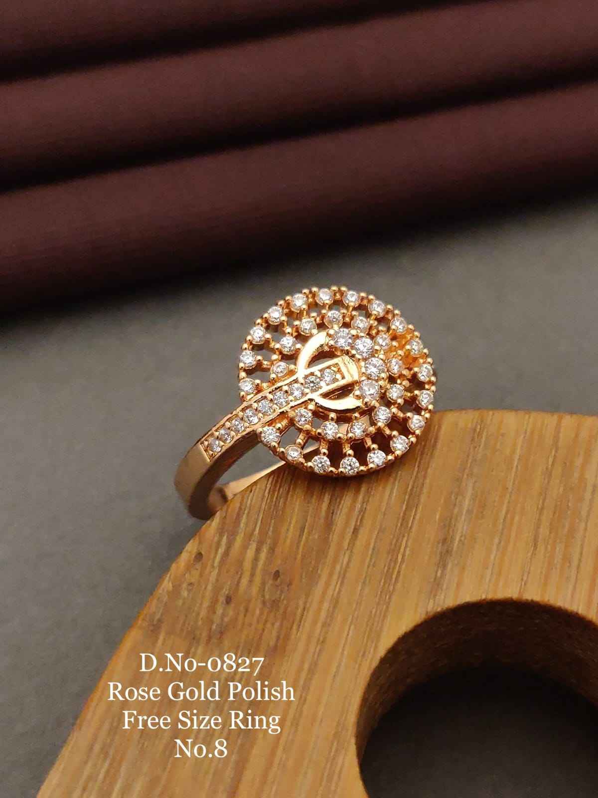 Rose gold ring with diamonds on a wooden stand against a brown fabric background