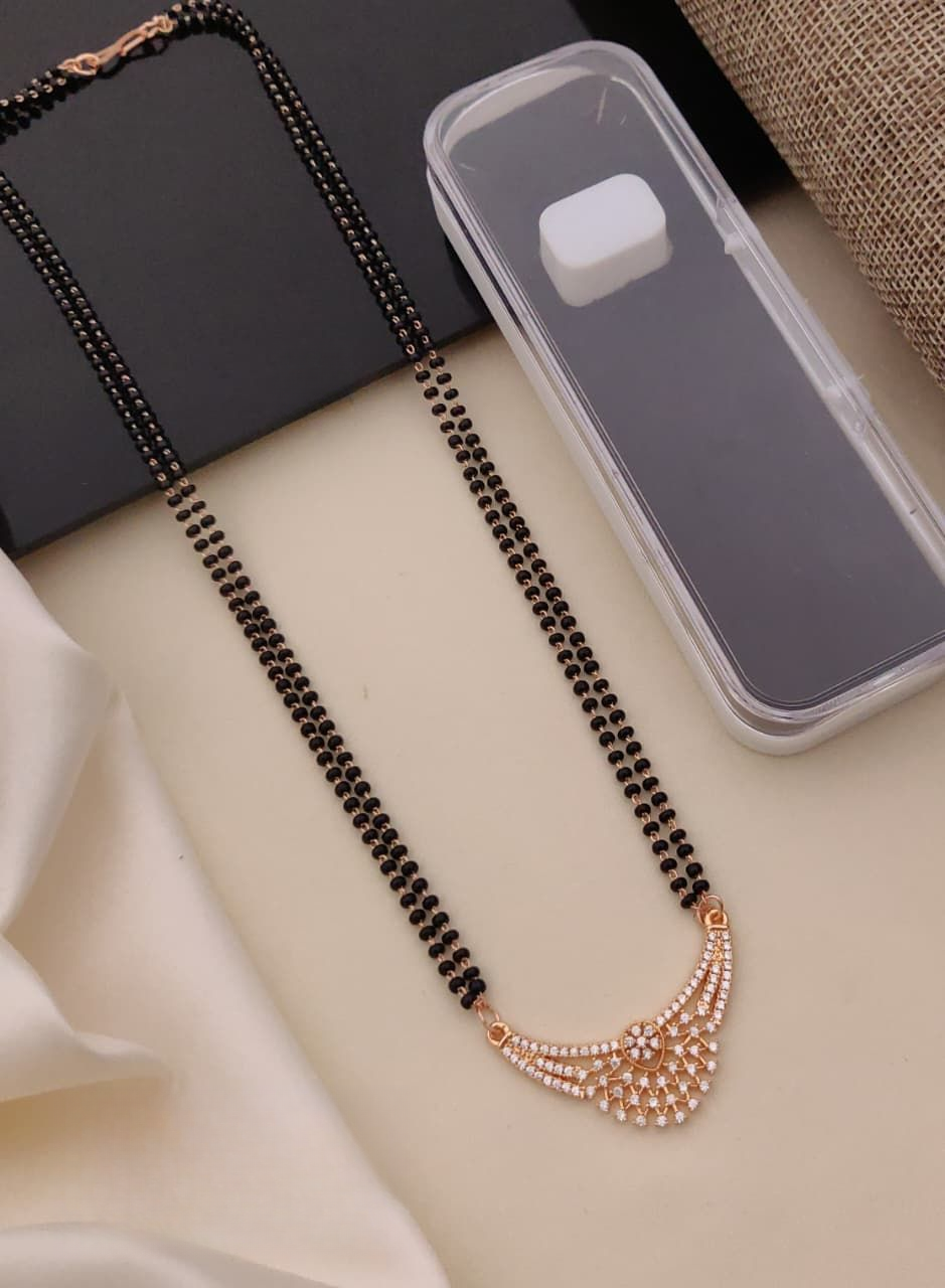 Black beaded necklace with rose gold accents on a light surface