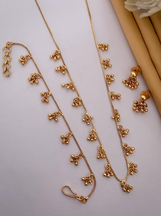 Gold necklace with floral pendants on a light gray background
