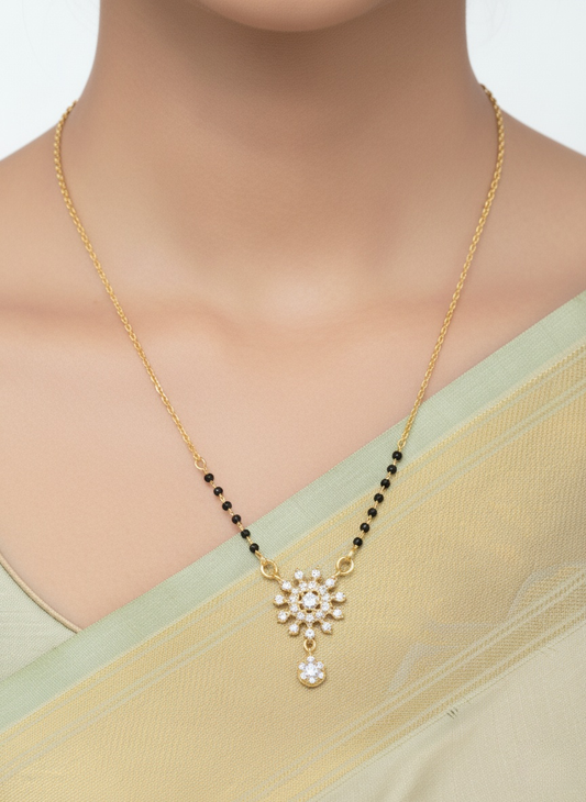 Gold necklace with a pendant on a model wearing a light green saree.