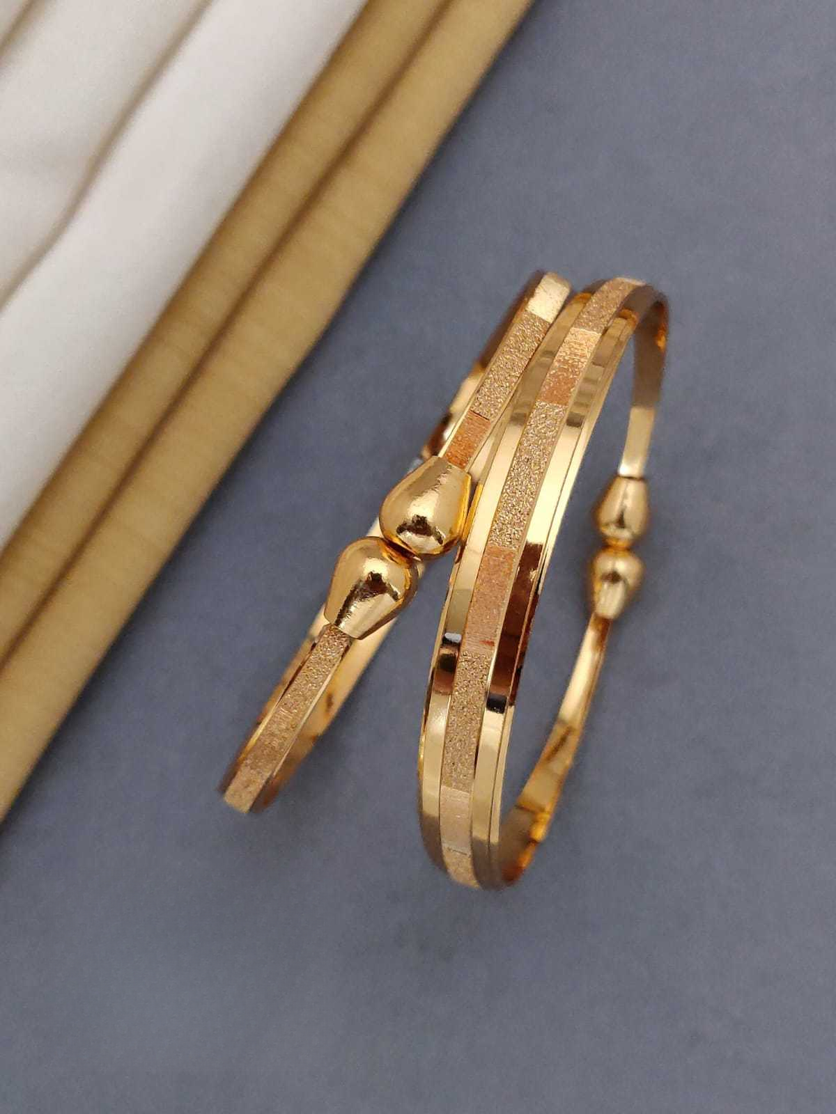 Gold bracelet on a gray surface with a neutral background