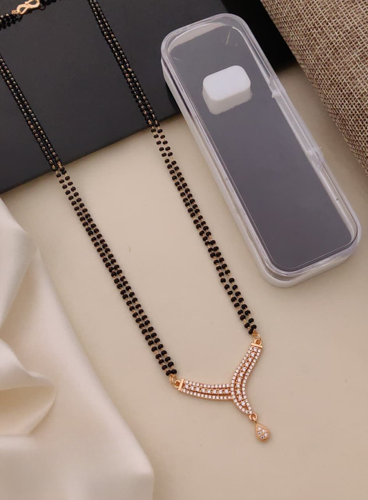 Black beaded necklace with rose gold accents on a light surface