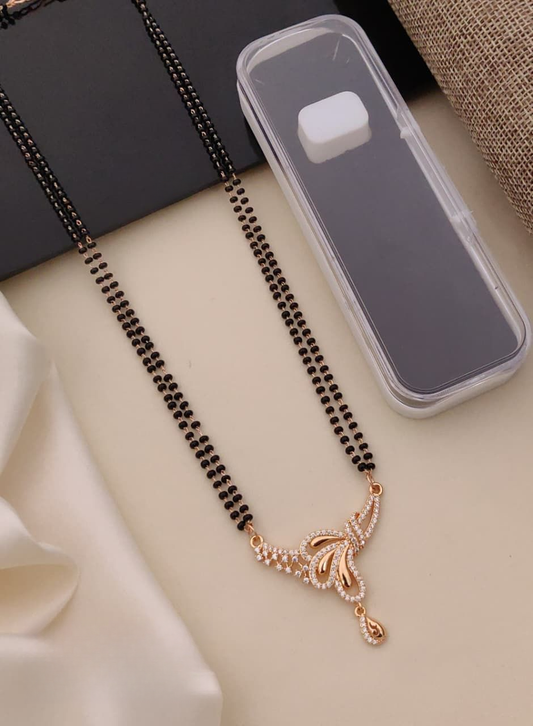 Black beaded necklace with a gold pendant on a light surface