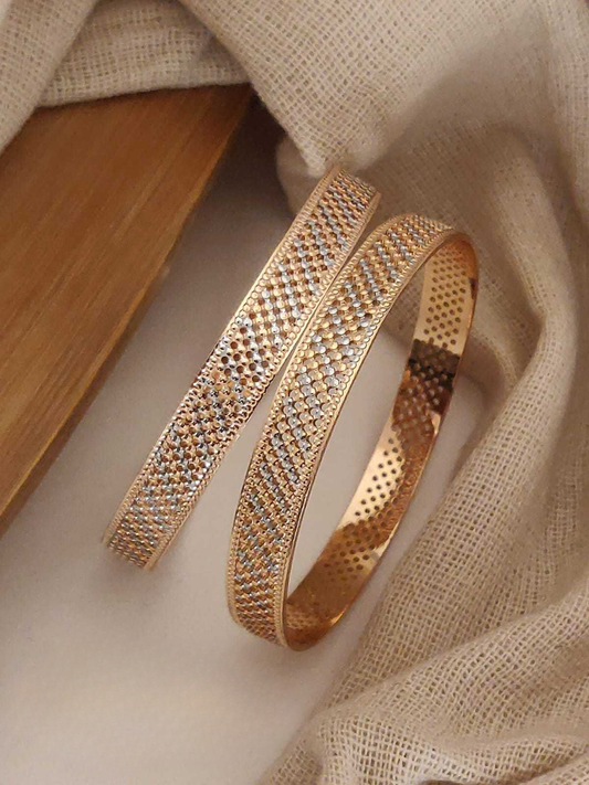 Gold bracelet with intricate design on a beige fabric background