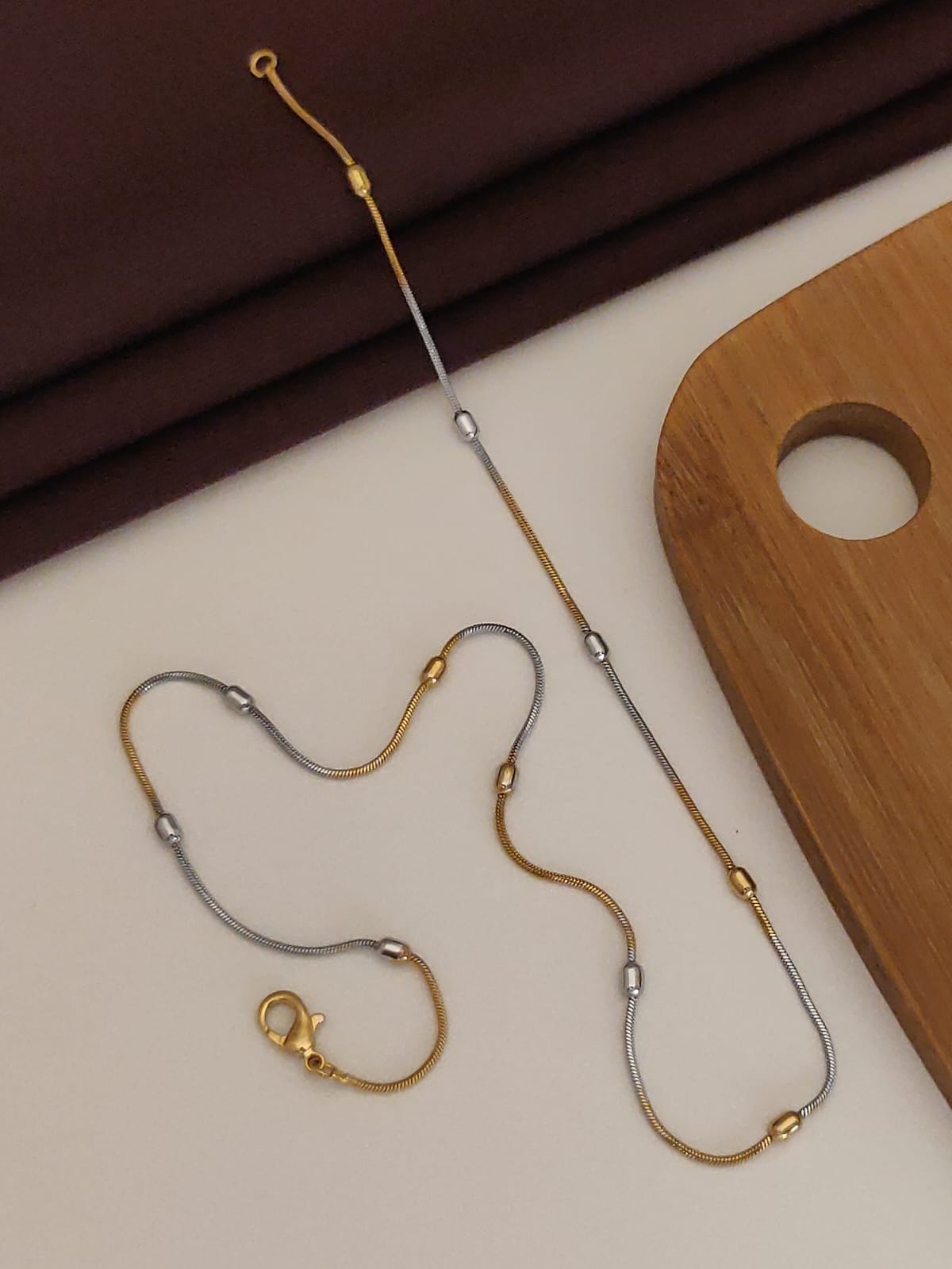 Gold and silver eyeglass chain on a neutral background