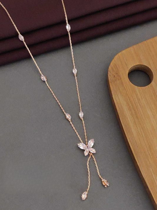 Delicate necklace with floral design on a gray surface with wooden background